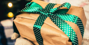 Closeup of a gift wrapped with a green polka dot ribbon
